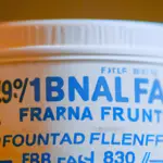 P of a full, unopened can of baby formula, showing the expiration date stamped on the bottom
